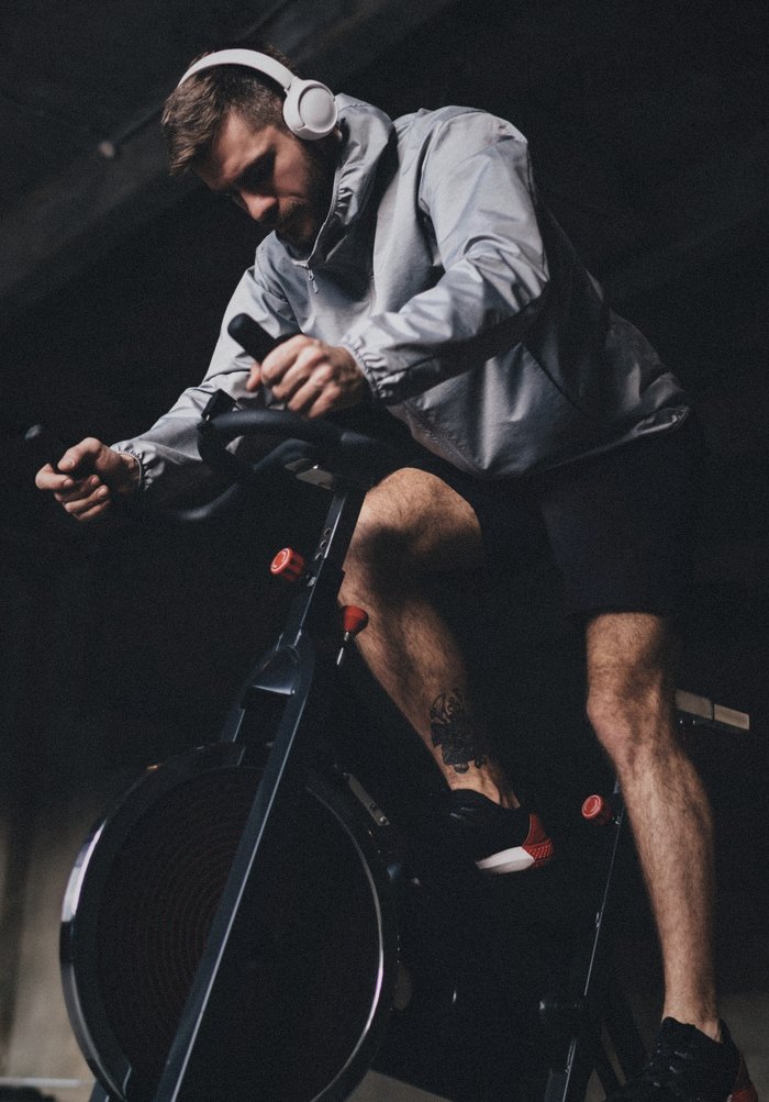 Athlet mit Kopfhörern auf dem Air Bike